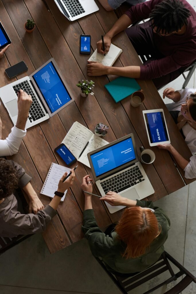 pexels-photo-3183188-3183188 A diverse group of professionals brainstorming with laptops and notepads in a modern office.