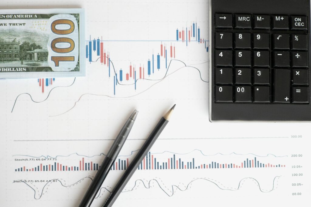 pexels-photo-6801639-6801639 Stock analysis workspace featuring charts, a calculator, and currency for data-driven insights.